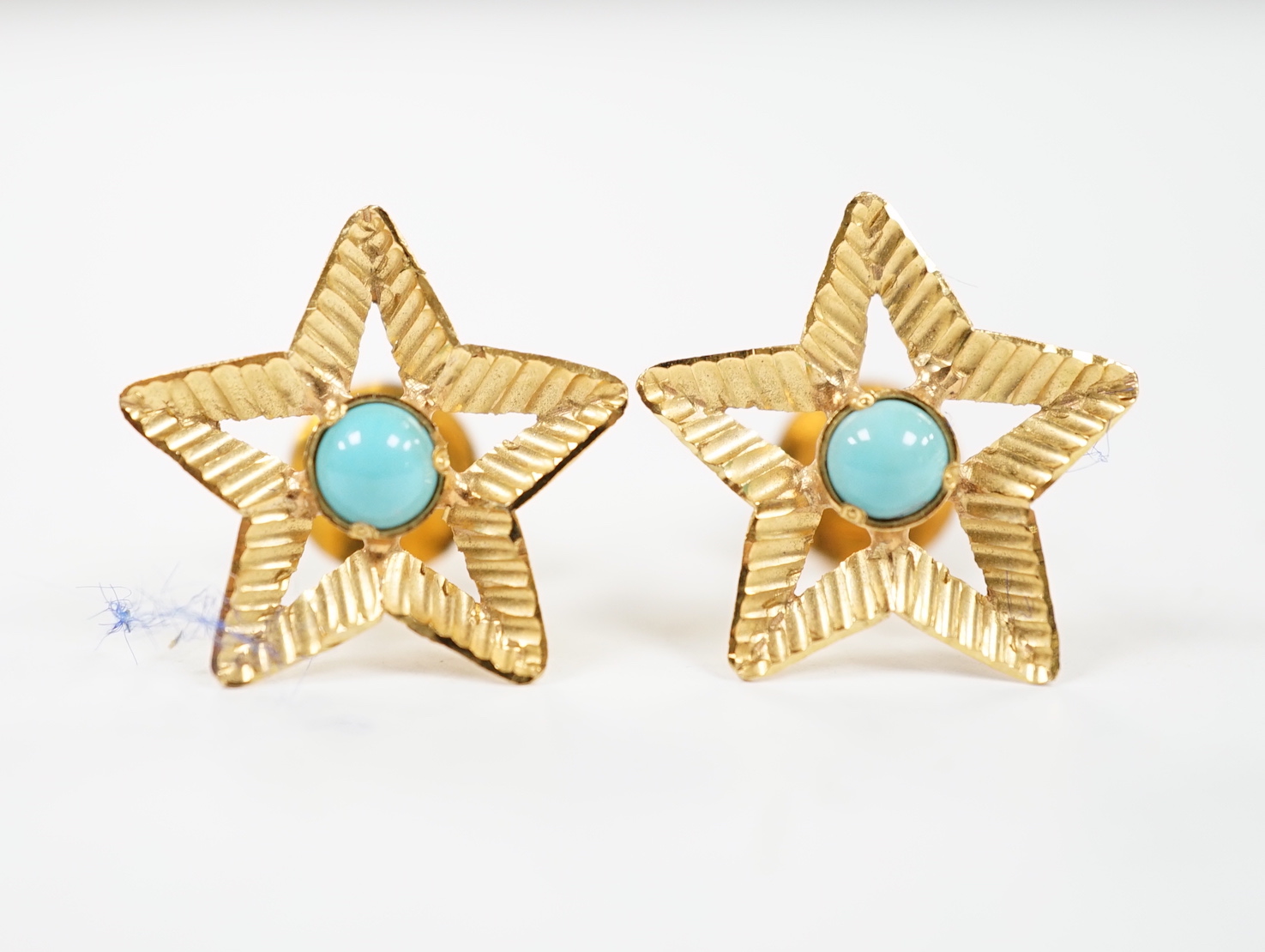 A pair of yellow metal and single stone turquoise set star earrings, 15mm, gross weight 2.4 grams.